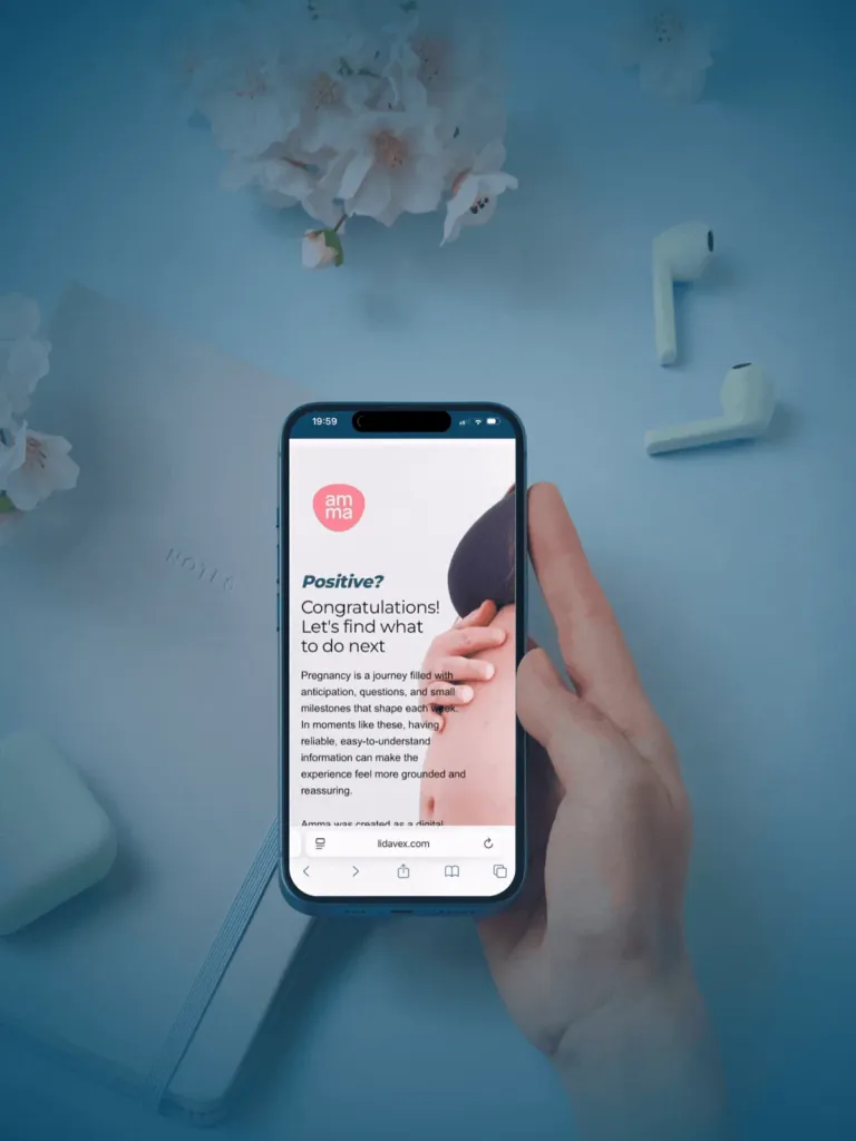A hand holding a smartphone open at lidavex.com, showing the amma logo and the heading “Positive? Congratulations! Let's find what to do next”